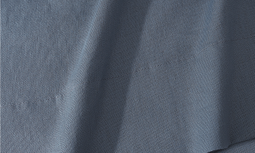 A close-up of draped slate blue fabric with a fine textured weave.